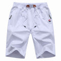 Men's white training shorts with a drawstring waist and zip pockets