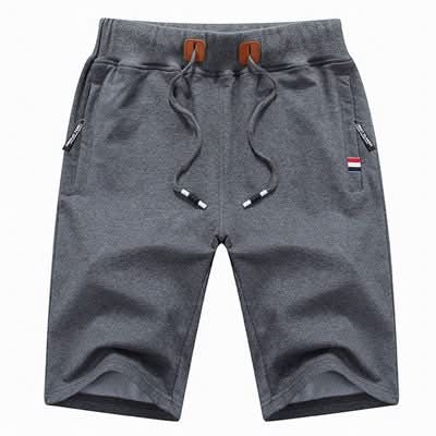 Men's white training shorts with a drawstring waist and zip pockets